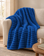 Plaid polaire côtelé Douillette, coloris bleu roi, sur un canapé