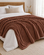 Plaid polaire côtelé Douillette, coloris chocolat, sur un lit, chambre en bois