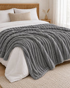 Plaid polaire côtelé Douillette, coloris gris anthracite, sur un lit, chambre en bois