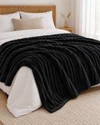 Plaid polaire côtelé Douillette, coloris noir, sur un lit, chambre en bois
