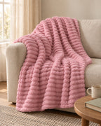 Plaid polaire côtelé Douillette, coloris rose poudré, sur un canapé
