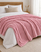 Plaid polaire côtelé Douillette, coloris rose poudré, sur un lit, chambre en bois