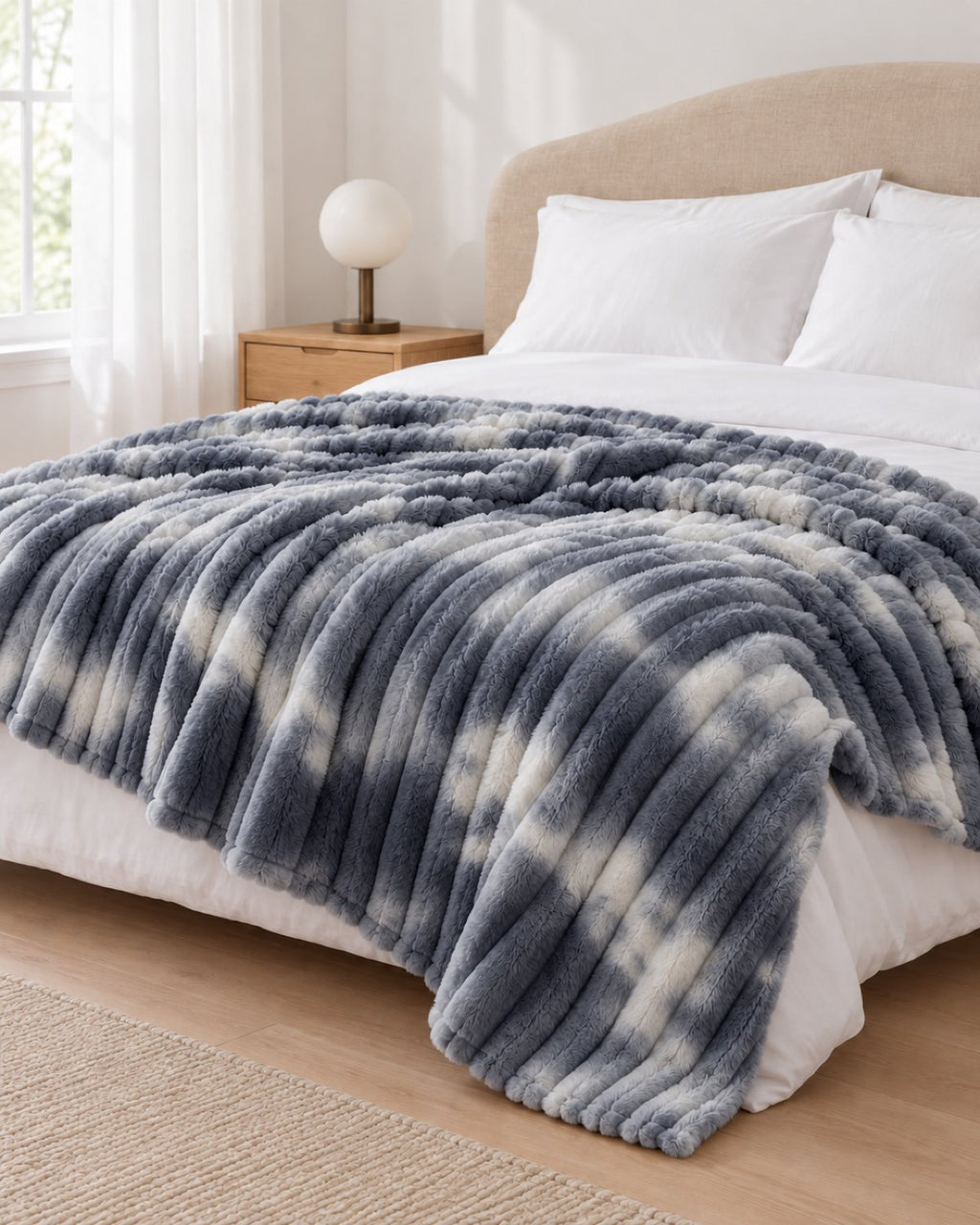 Plaid polaire côtelé Douillette, coloris tie-dye gris, sur un lit, chambre claire