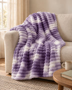 Plaid polaire côtelé Douillette, coloris tie-dye violet, sur un canapé