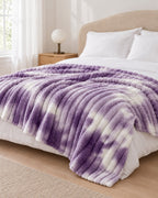 Plaid polaire côtelé Douillette, coloris tie-dye violet, sur un lit, chambre claire