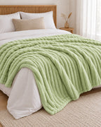 Plaid polaire côtelé Douillette, coloris vert sauge, sur un lit, chambre en bois